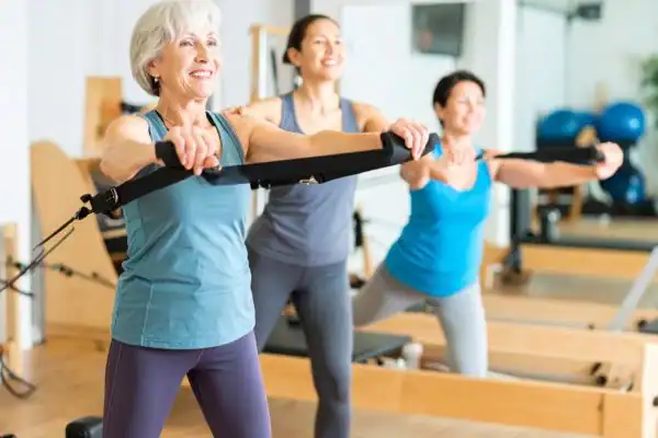 Toning Arms After 60: Empowering Womens Fitness Through Effective Weight Training 2 older woman doing weight training Rhyl and resistance in the gym to tone upper arms