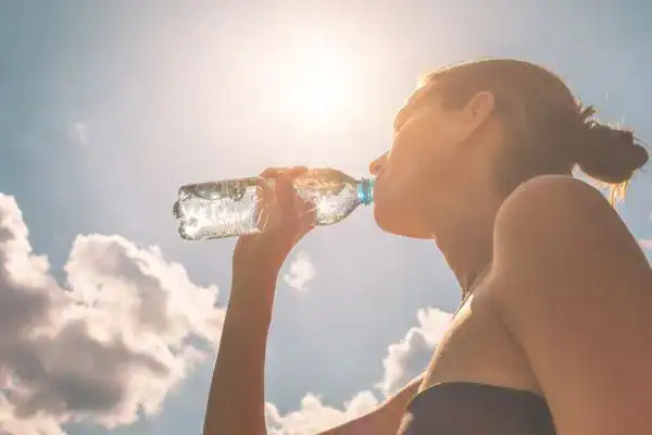 Hydration: The Secret Ingredient for a Toned Stomach and Enhanced Fitness 3 Image of woman drinking water to hydrate Rhyl after run.